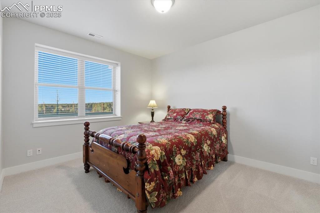 Image 43 of 49: The fourth bedroom is located on the basement level, with a garden-level wi