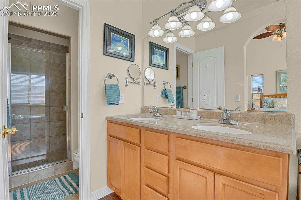 Image 13 of 41: Main level Primary bathroom showing double sinks & entry door to large show