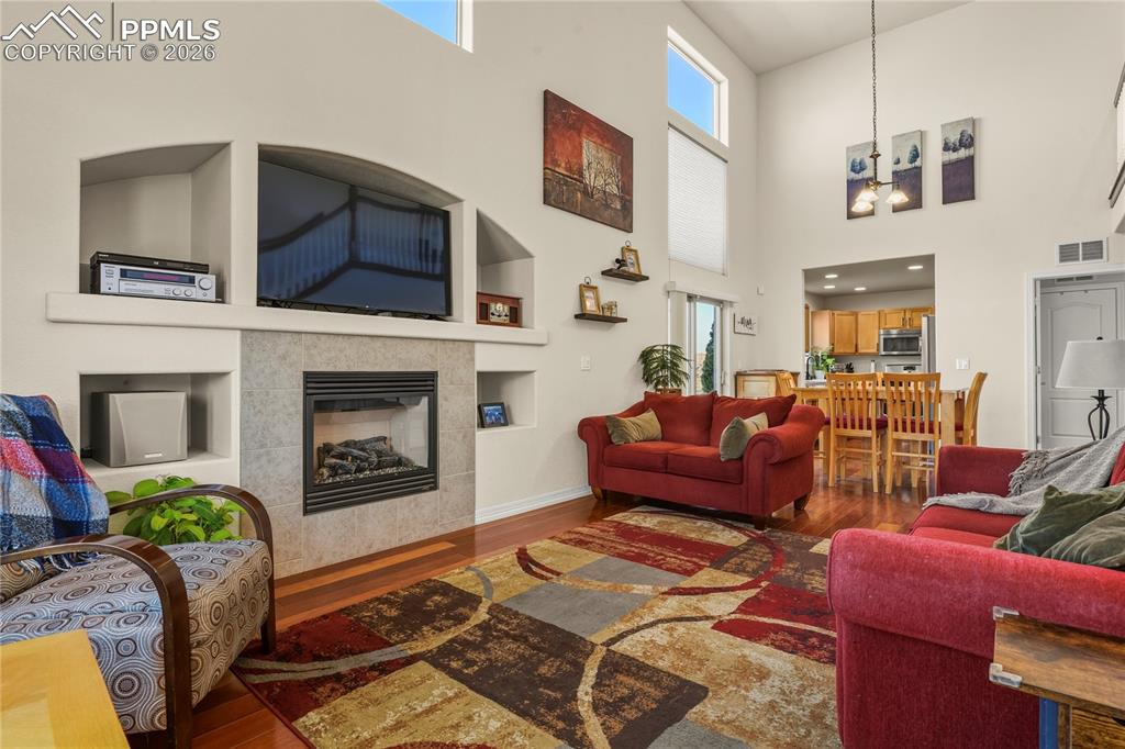 Image 15 of 41: Large, main level family room featuring gas fireplace, Brazilian wood floor