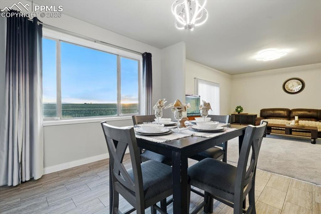 Image 10 of 30: Dining room featuring baseboards, a water view, and a chandelier