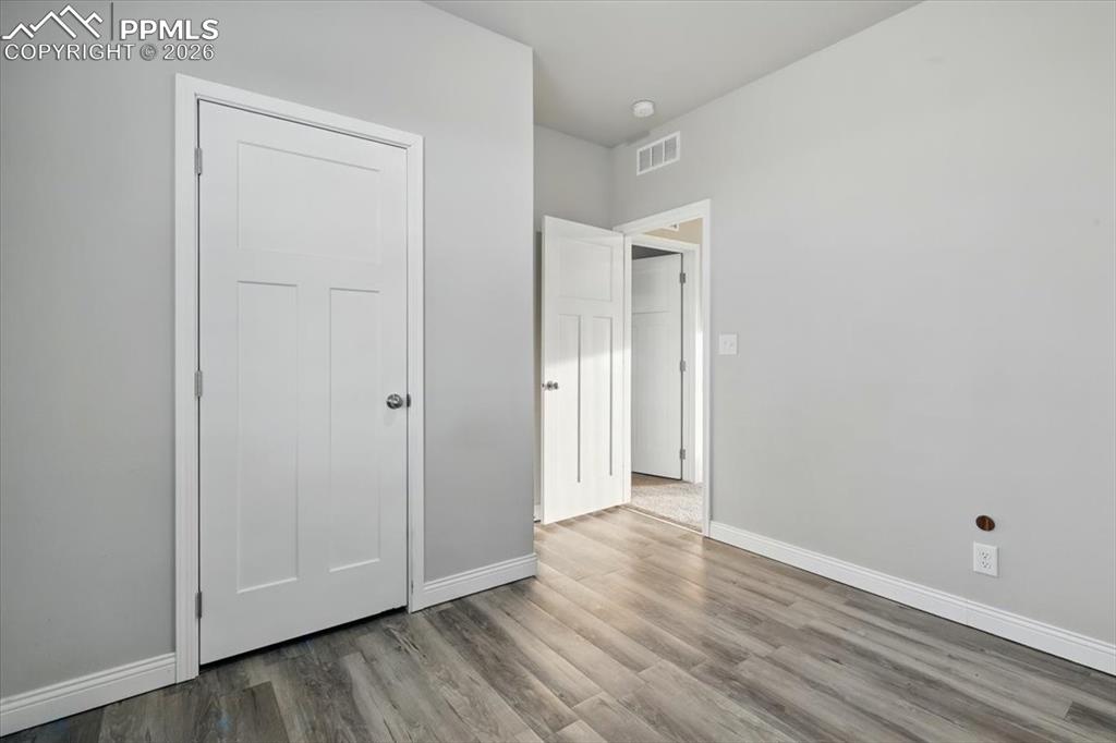 Image 25 of 30: Unfurnished bedroom with baseboards and wood finished floors