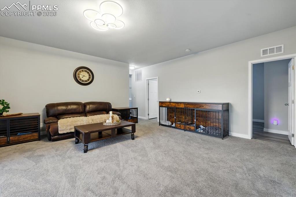 Image 7 of 30: Carpeted living area with baseboards
