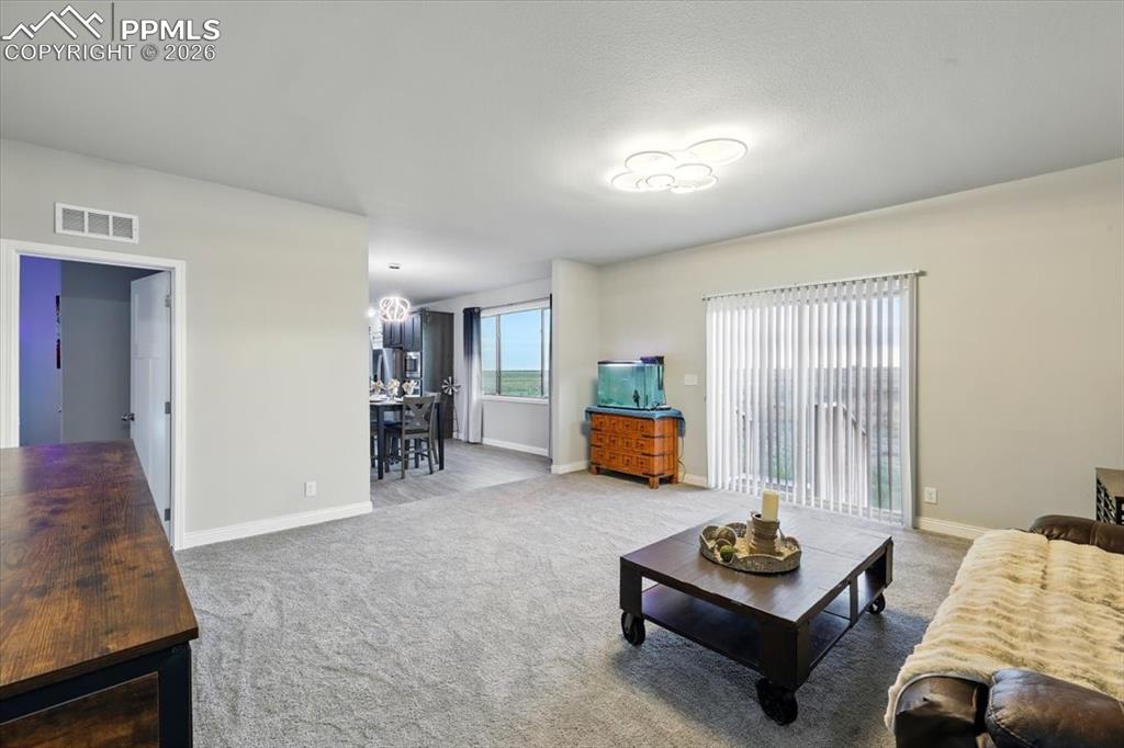 Image 8 of 30: Living room featuring carpet and baseboards