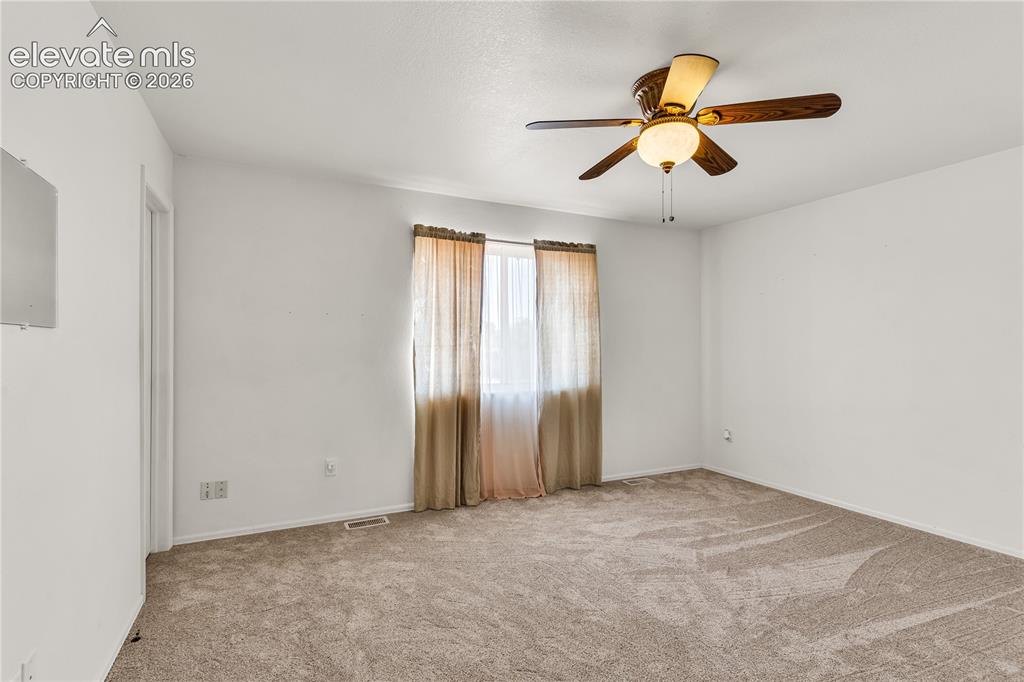 Image 15 of 32: Ceiling fan with integrated lighting, neutral carpet flooring, and window w