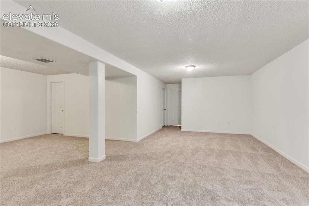 Image 19 of 32: Spacious room with light-toned carpeting and neutral wall finishes