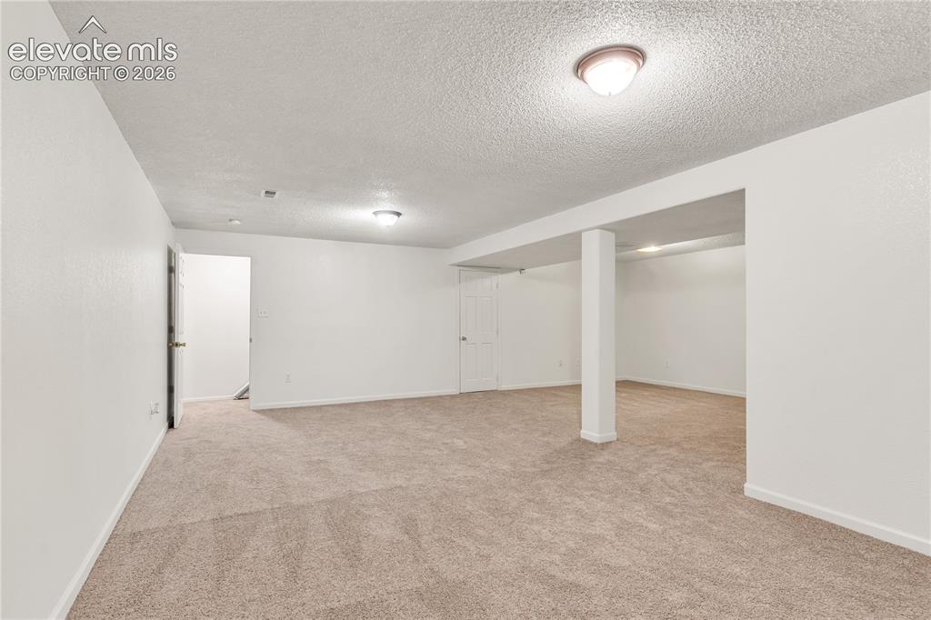 Image 20 of 32: Neutral carpet flooring, white painted walls, ceiling-mounted lighting, and