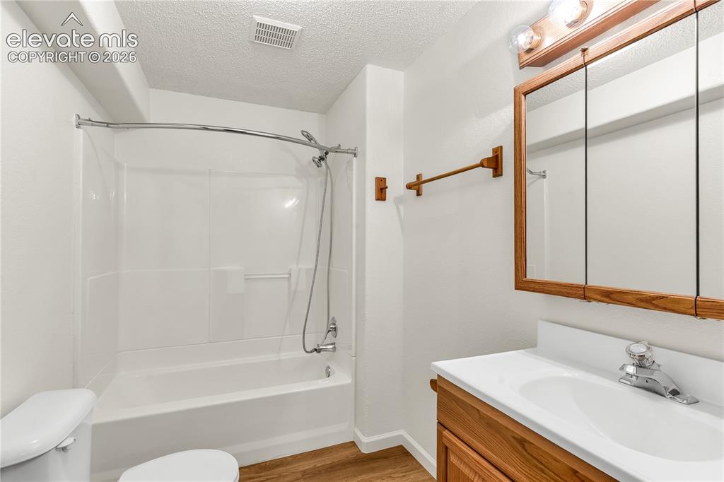 Image 21 of 32: Bathroom featuring wood-finish flooring, a white integrated sink with lamin