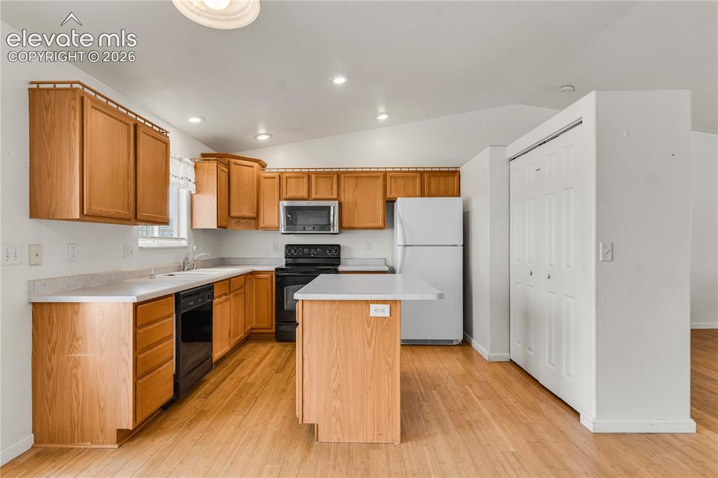 Image 8 of 32: Kitchen featuring wood-finish cabinetry, light-colored countertops, wood-fi