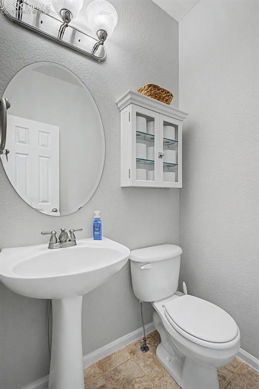 Image 15 of 49: Pedestal sink with a chrome faucet set below an oval wall mirror
