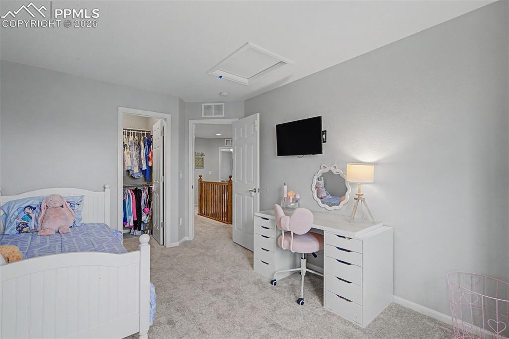Image 26 of 49: Carpeted room with light grey walls, featuring a built-in closet with doubl