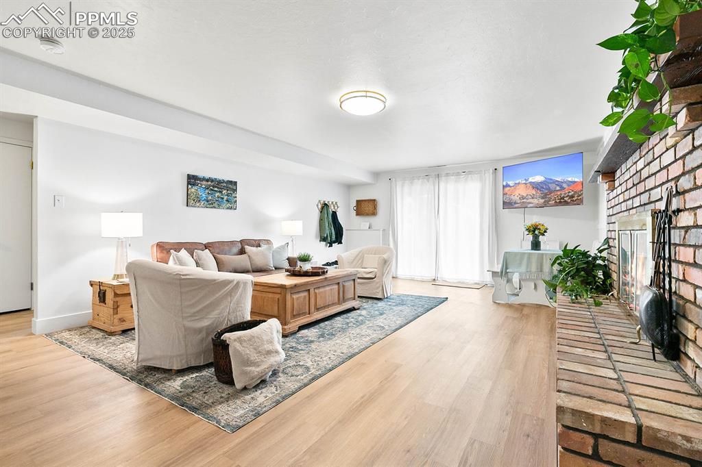 Image 21 of 45: Living area with light wood-style floors and a fireplace
