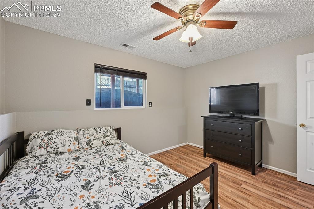 Image 22 of 23: Bedroom featuring light wood finished floors, a textured ceiling, and a cei