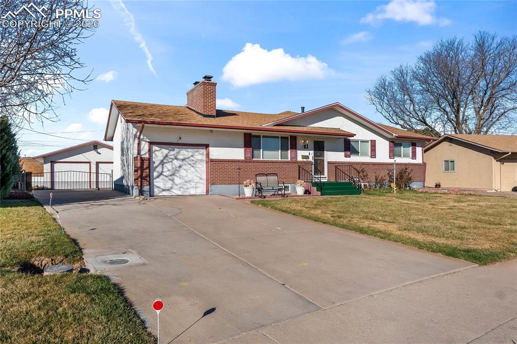 Image 1 of 41: View of front facade with a front yard, brick siding, concrete driveway, a 