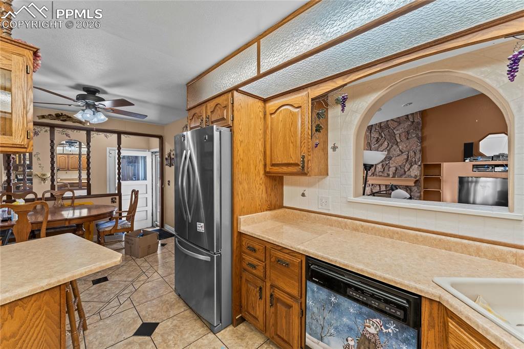 Image 11 of 41: Kitchen with light countertops, dishwasher, freestanding refrigerator, and 