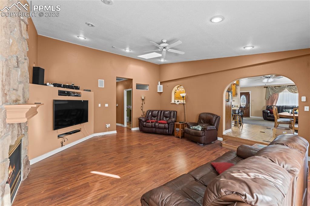 Image 14 of 41: Living area featuring ceiling fan, arched walkways, wood finished floors, a