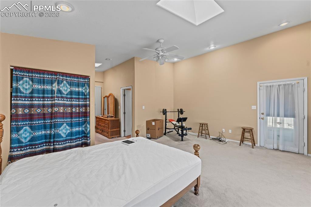 Image 18 of 41: Bedroom featuring light colored carpet, access to exterior, a skylight, a c