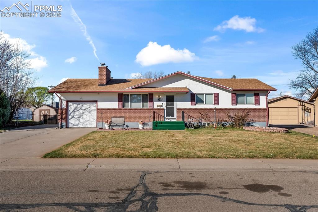 Image 2 of 41: View of front of property featuring a front lawn, an outdoor structure, a c