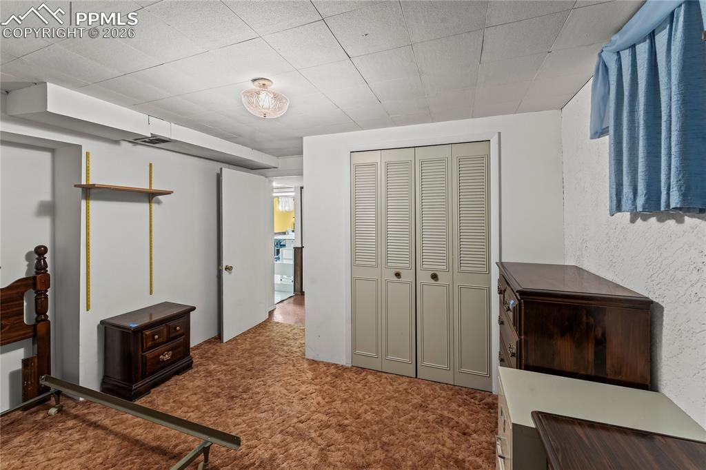 Image 24 of 41: Unfurnished bedroom with a closet, dark carpet, and a textured wall