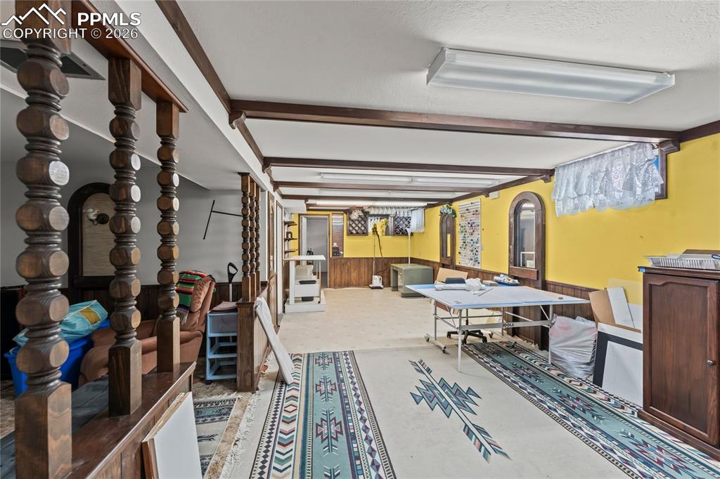 Image 30 of 41: Below grade area with a wainscoted wall, wooden walls, and a textured ceili