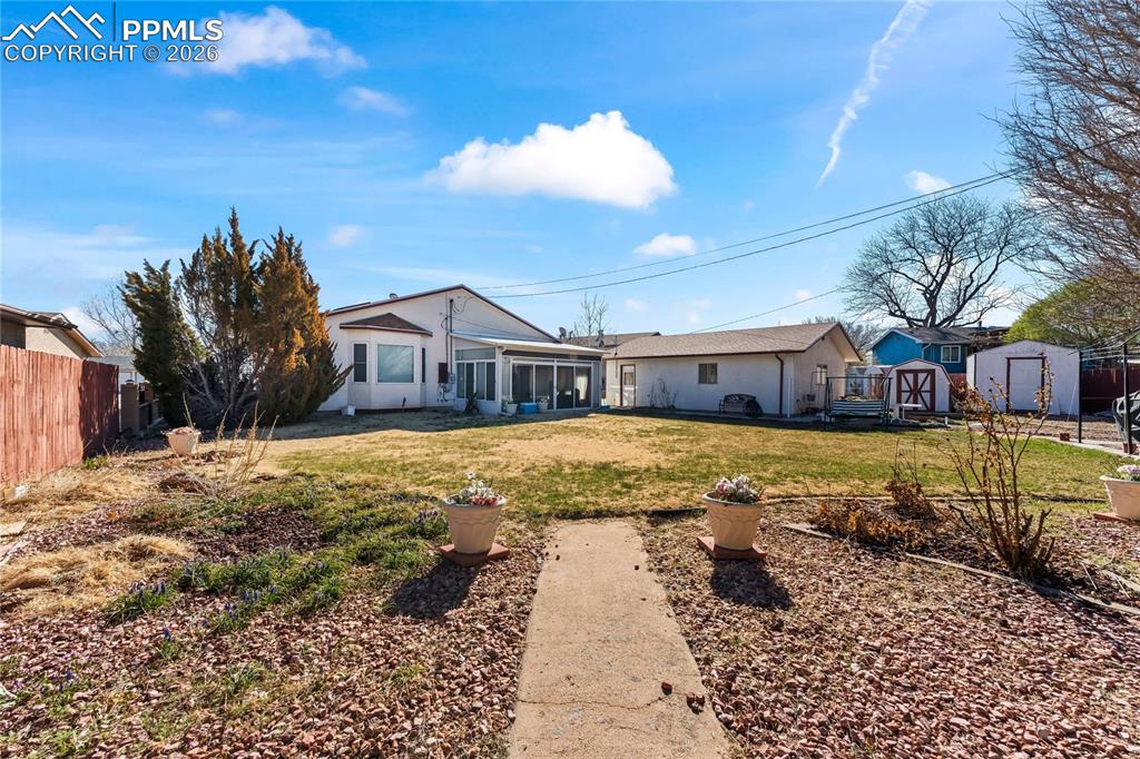 Image 37 of 41: Back of house featuring a shed and a sunroom