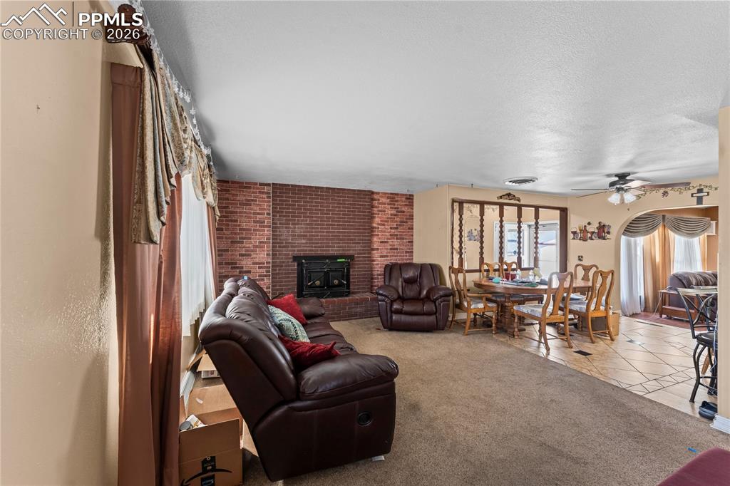 Image 4 of 41: Living area featuring light carpet, a ceiling fan, light tile patterned flo