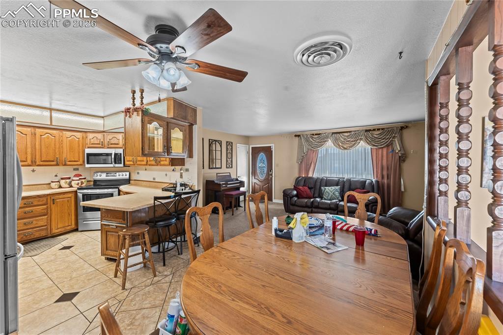 Image 7 of 41: Dining space featuring ceiling fan and light tile patterned flooring