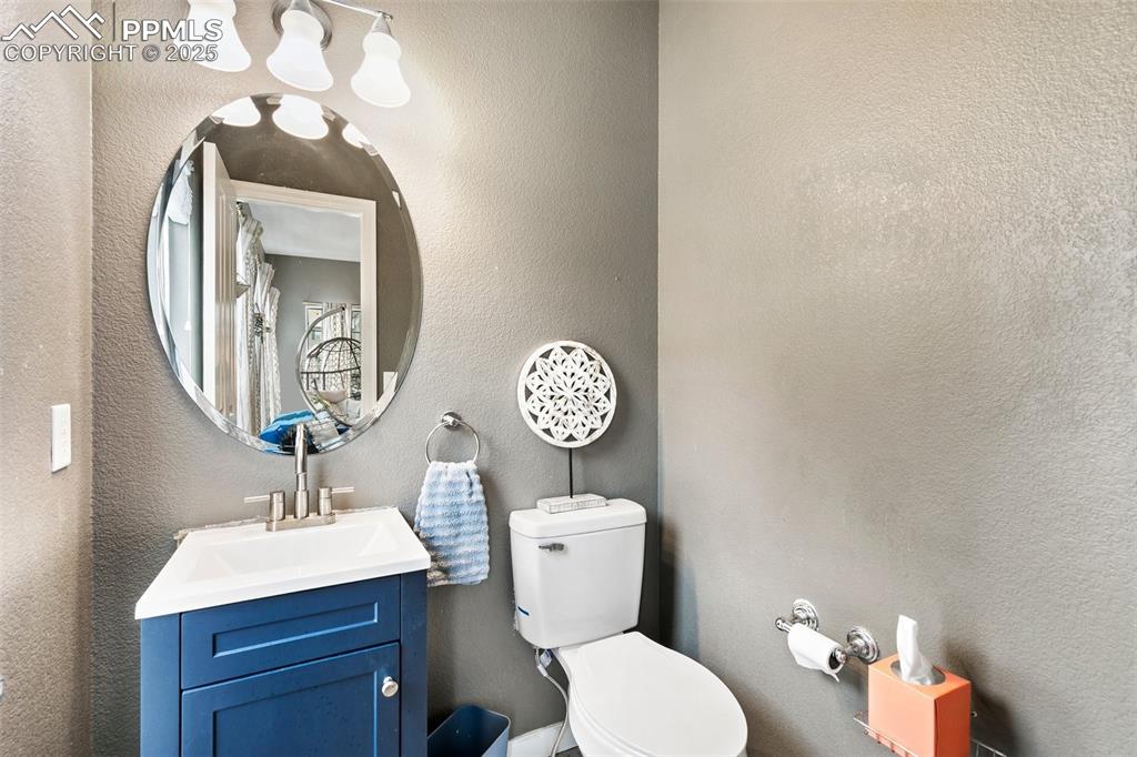 Image 18 of 34: Bathroom featuring toilet, vanity, and a textured wall