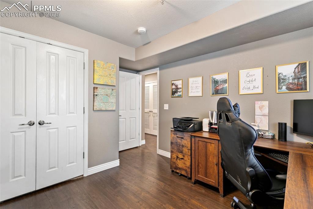 Image 20 of 34: Office area featuring dark wood finished floors and baseboards