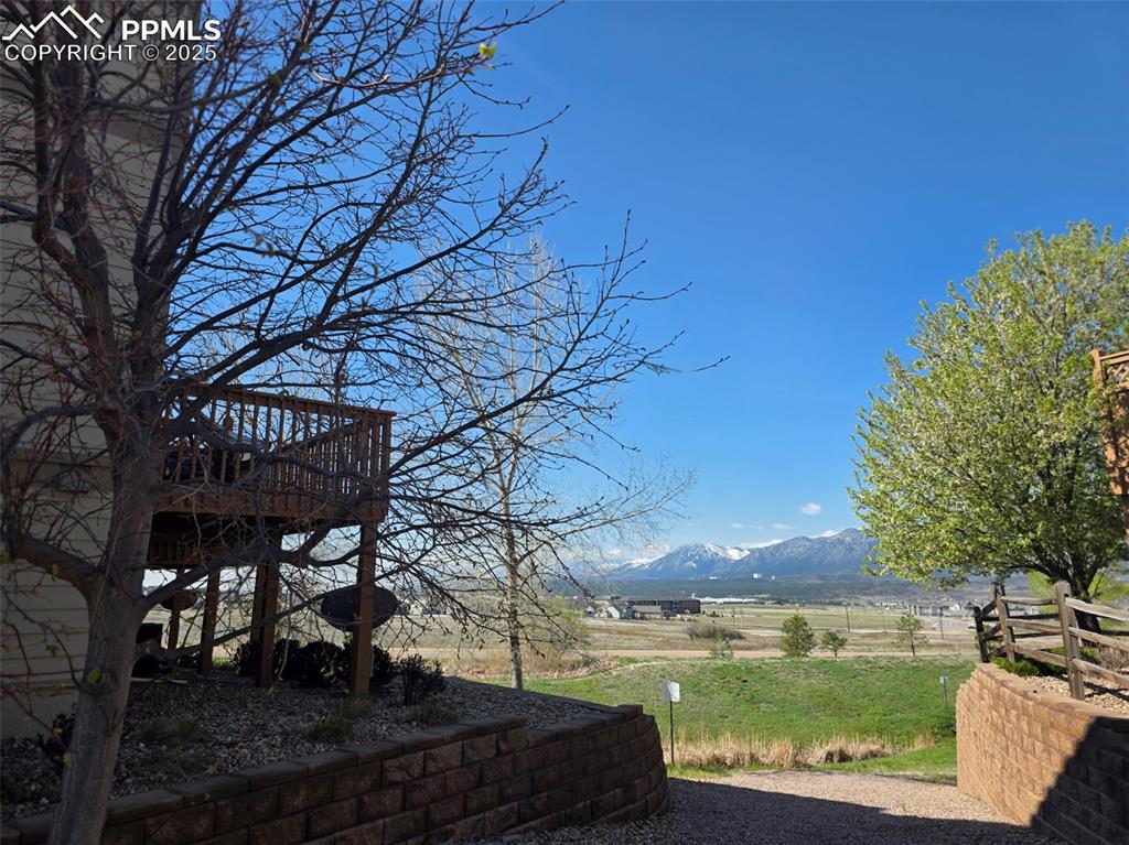 Image 31 of 34: View of yard featuring a deck with mountain view and a view of rural / past