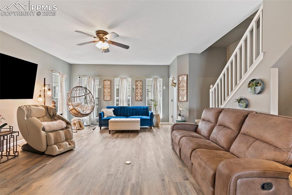Image 5 of 34: Living area featuring ceiling fan, wood finished floors, baseboards, and st