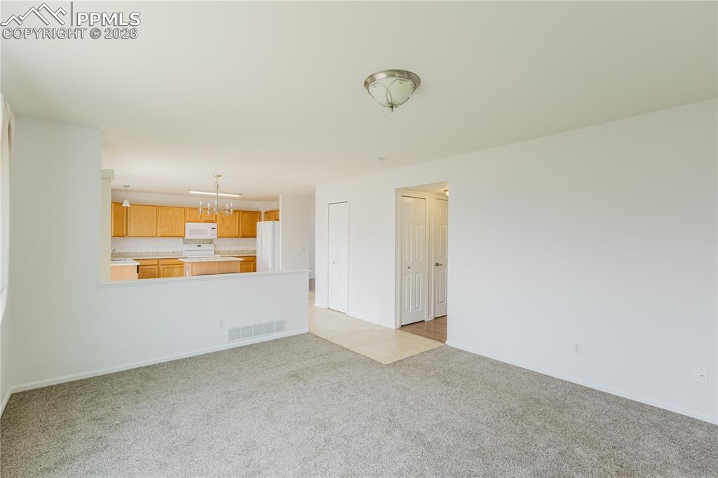 Image 16 of 42: The open concept layout features a kitchen island with a granite countertop