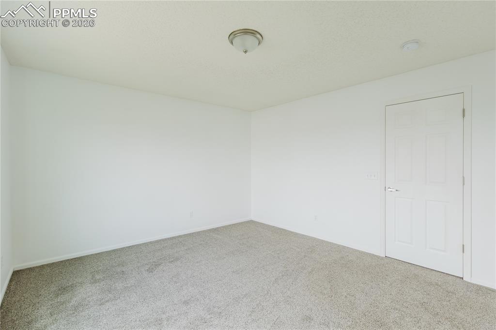 Image 19 of 42: Open concept living space featuring a large window with drapes, grey carpet