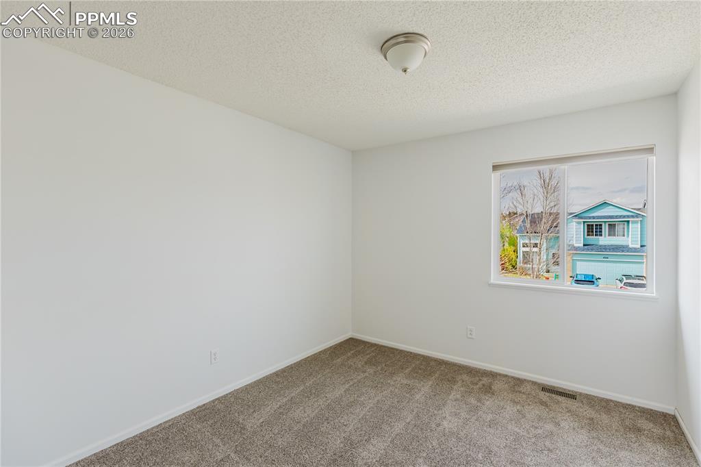 Image 25 of 42: This room  features a window providing natural light, white walls, and carp