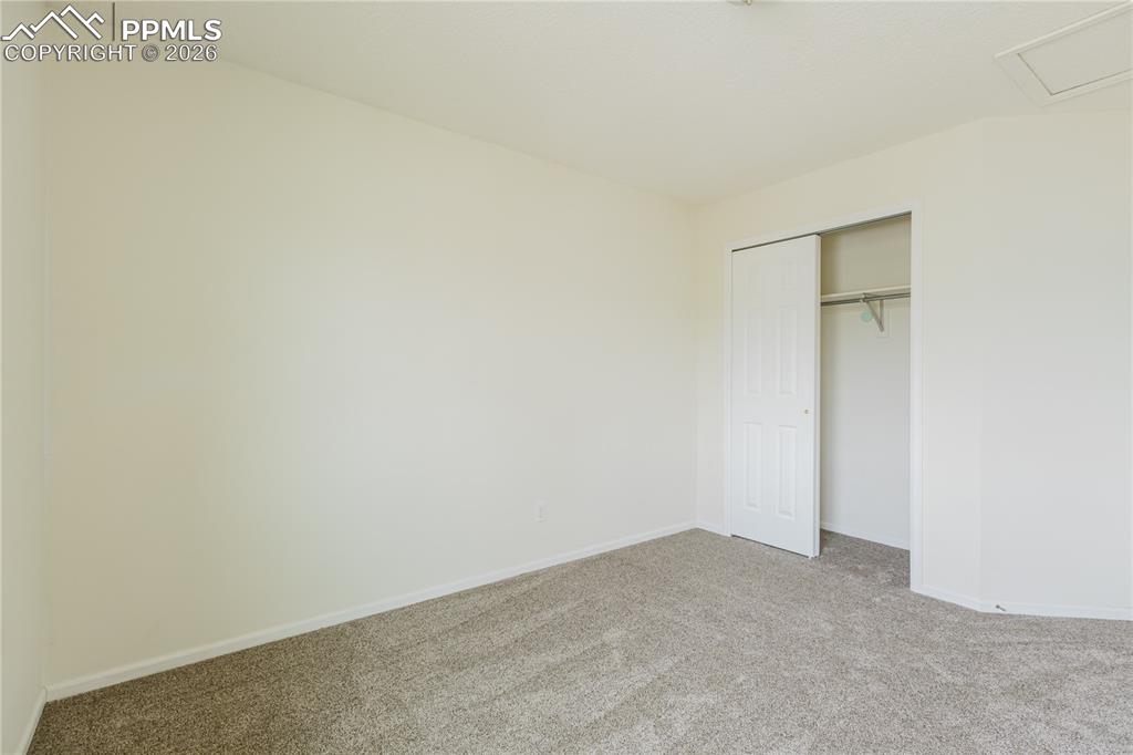 Image 28 of 42: The property features light-colored walls and carpet throughout, with a hal