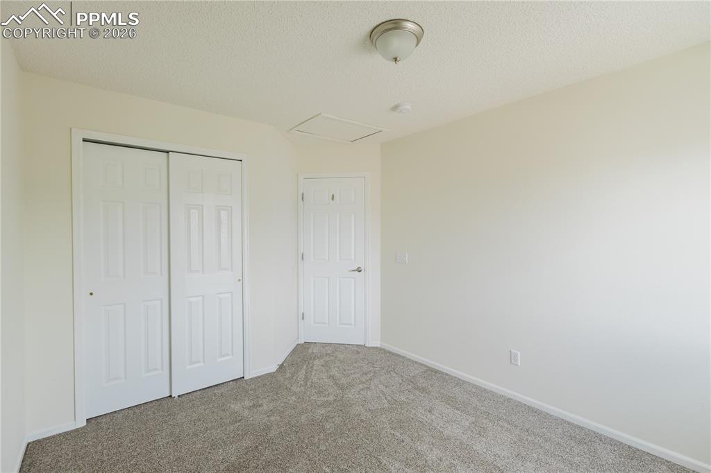 Image 29 of 42: This bedroom features neutral-toned carpet and white walls, offering a vers