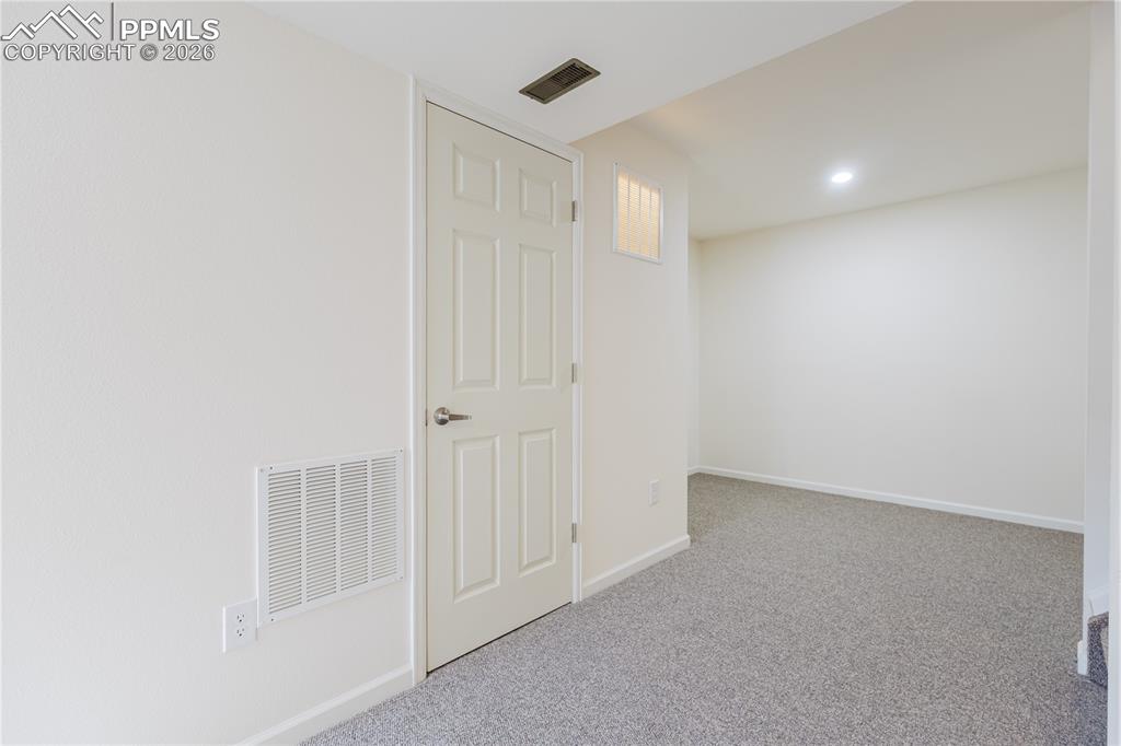 Image 33 of 42: This room features light-colored walls, neutral colored carpet flooring, an