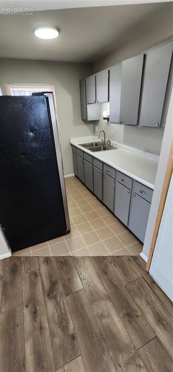 Image 13 of 18: Apt 4 - Kitchen space featuring gray cabinetry, a dual basin stainless stee