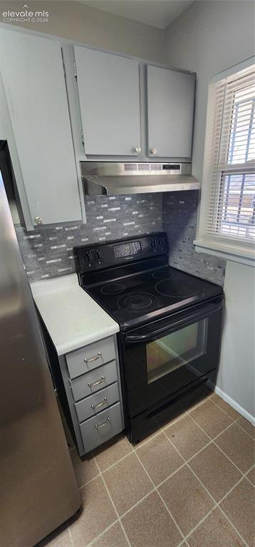 Image 14 of 18: Apt 4 - Gray cabinetry with silver hardware, full-size black range, stainle