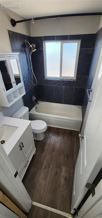 Image 16 of 18: Apt 4 - Bathroom featuring a bathtub with shower, dark tile surround with m