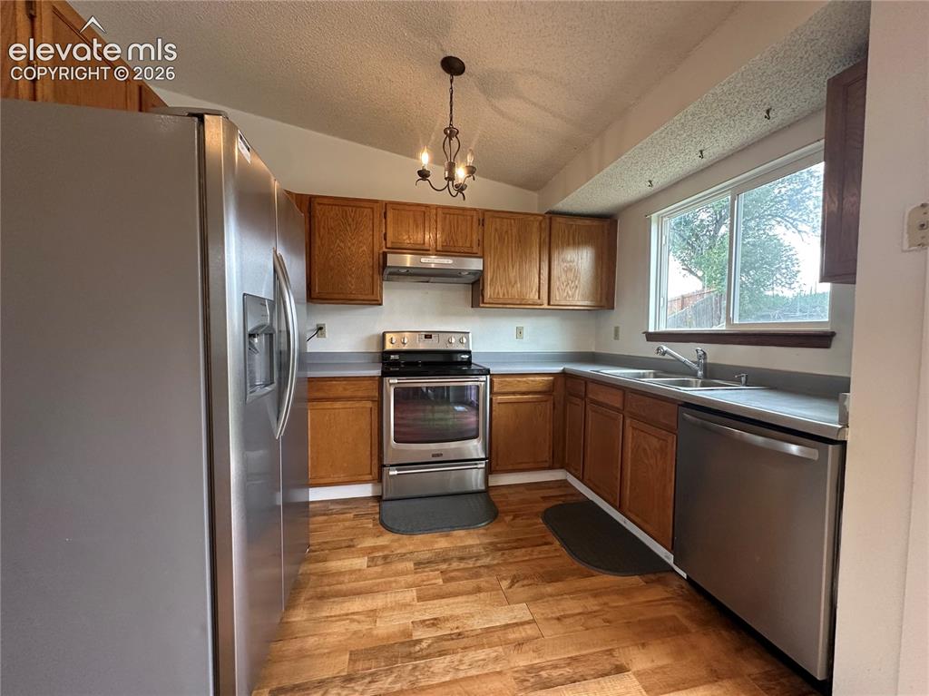 Image 3 of 15: Kitchen featuring wood-finish flooring, stainless steel appliances, wood ca