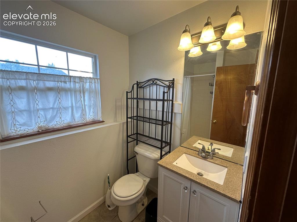 Image 8 of 15: Bathroom featuring a white vanity with double-door cabinetry, a light-color