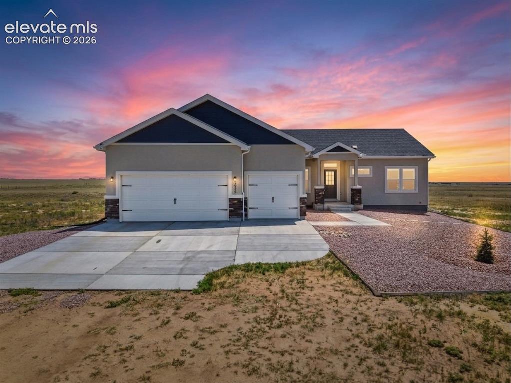 Image 1 of 38: Contemporary stucco home featuring a dark shingle roof and contrasting dark