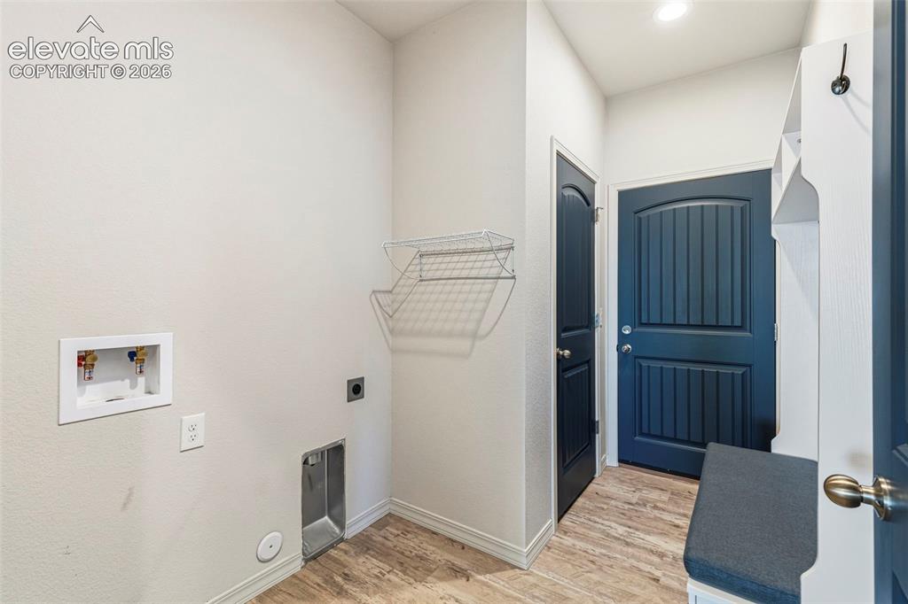 Image 19 of 38: Functional utility room featuring wood-finish flooring, laundry hookups, an