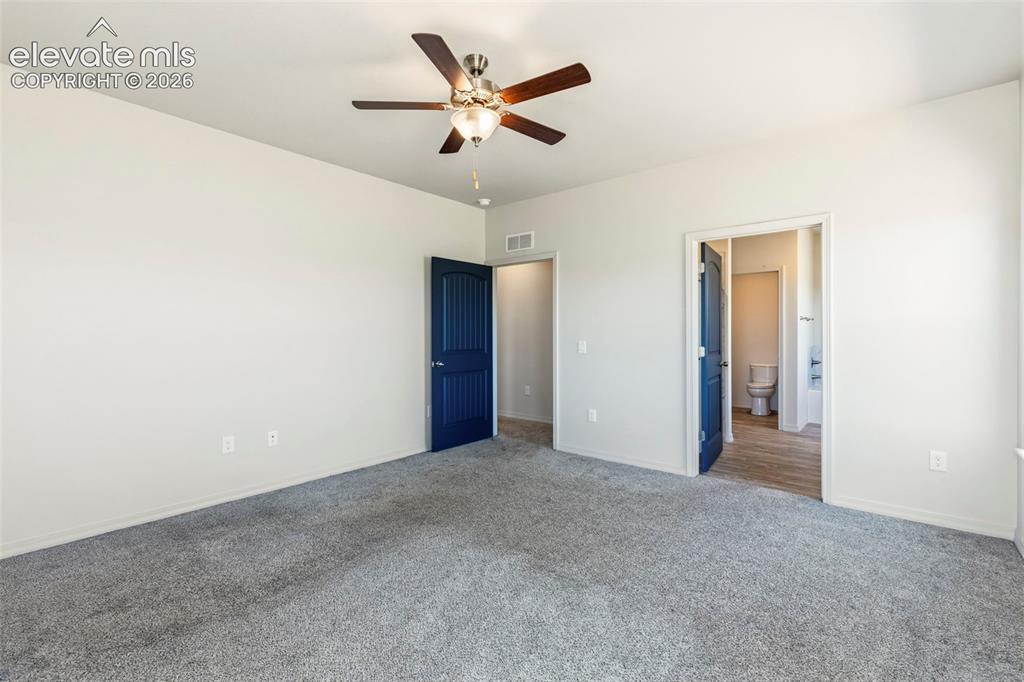 Image 21 of 38: Spacious room featuring plush gray carpeting, crisp white walls, and a ceil