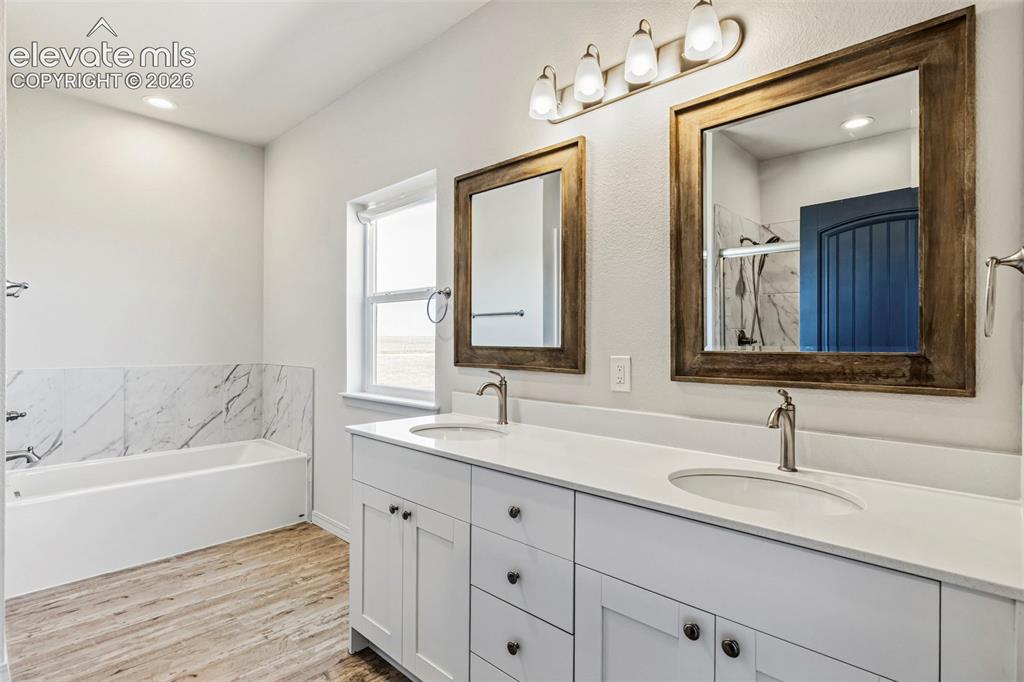Image 22 of 38: Dual vanity featuring white cabinetry with dark hardware, undermount sinks,