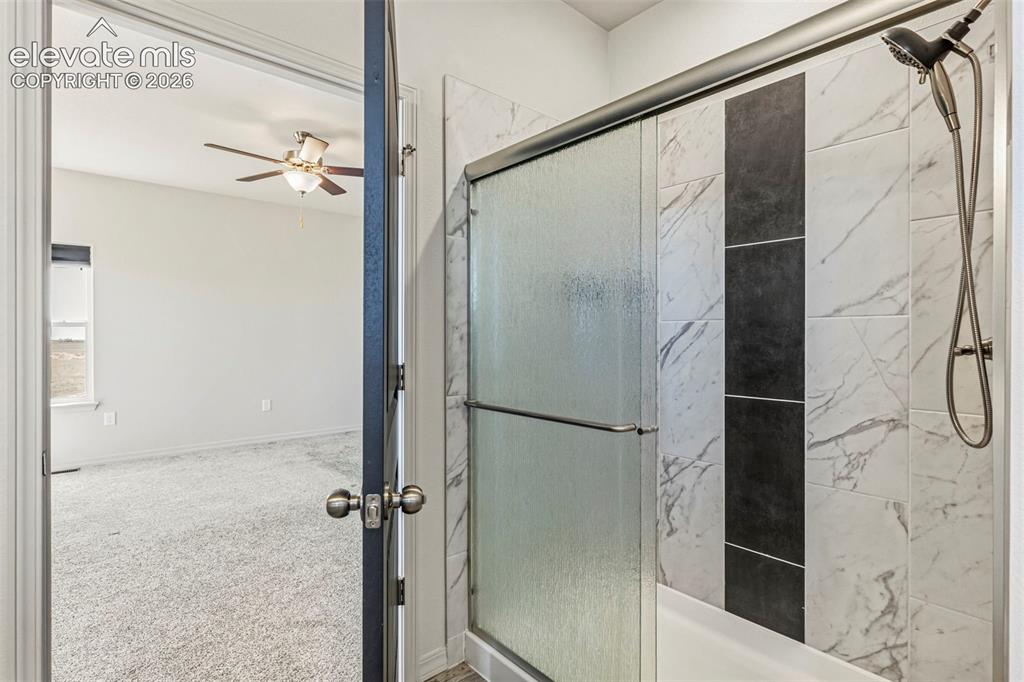 Image 23 of 38: Contemporary shower enclosure with a sliding frosted glass door and a rain