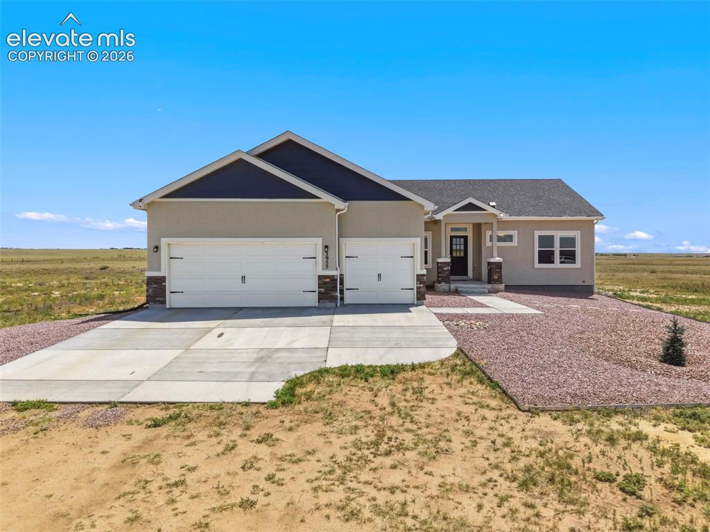 Image 4 of 38: Contemporary ranch-style exterior with stucco siding and stone veneer accen