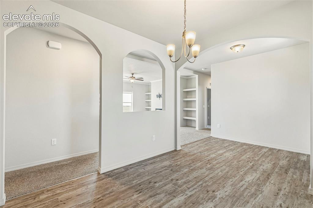 Image 8 of 38: Dining area featuring wood-finish flooring, a contemporary chandelier, and
