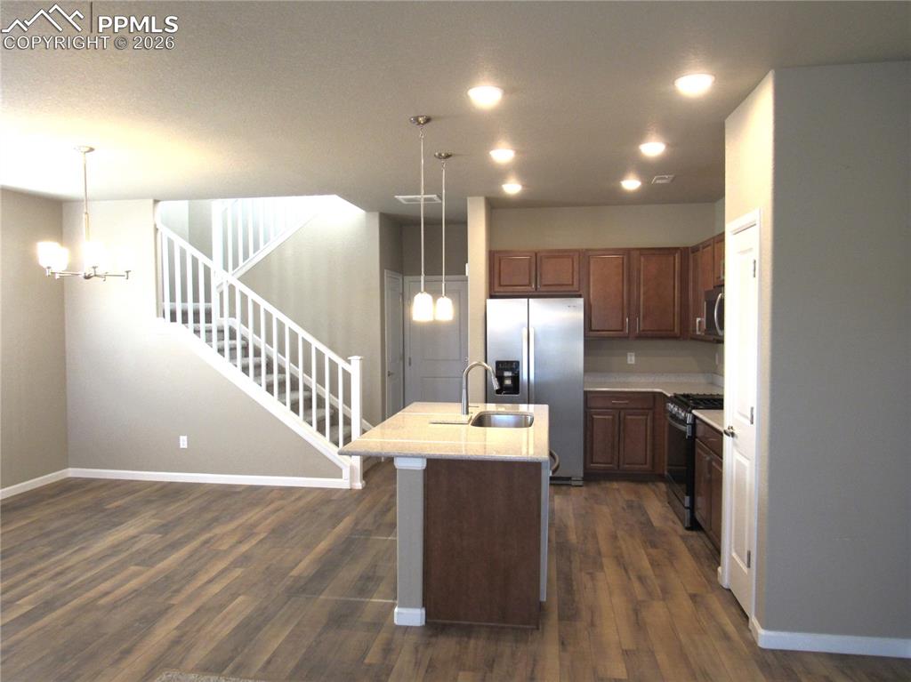 Image 10 of 25: View of kitchen with open railing leading to the upper level