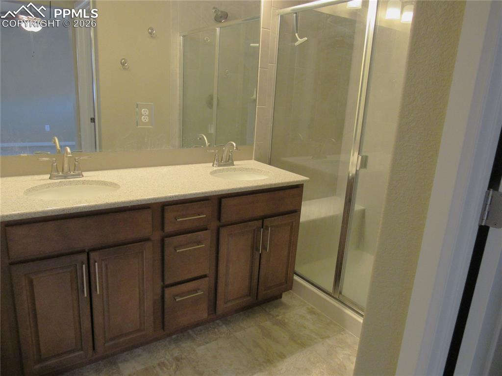 Image 14 of 25: Double vanity and walk-in shower with shower bench